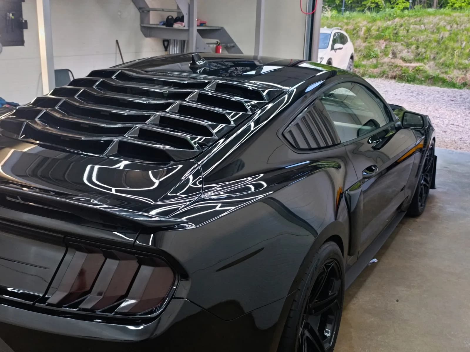 Ford Mustang GT — Kelių pakopų kėbulo poliravimas — sodrus, veidrodinis juodo lako paviršius studijoje.